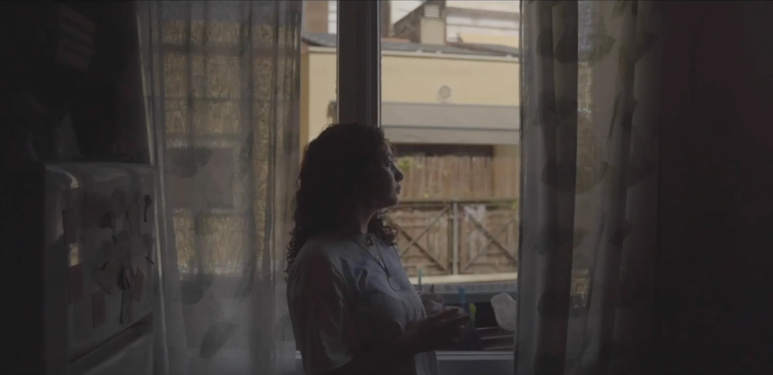 A girl at a window behind a sheer curtain — ActFem