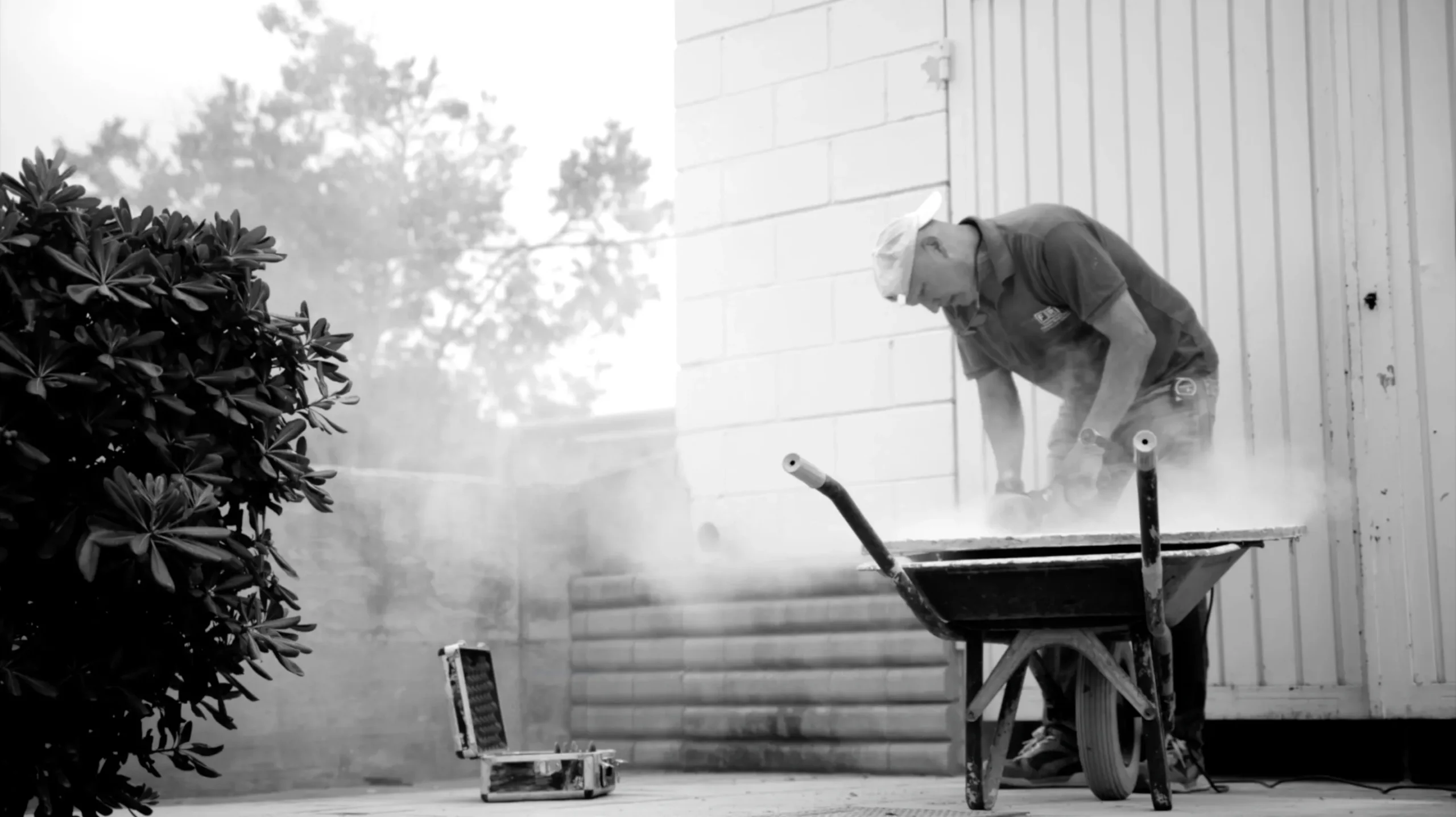 A gravedigger with a wheelbarrow in a cloud of dust — El Sisè Cicle