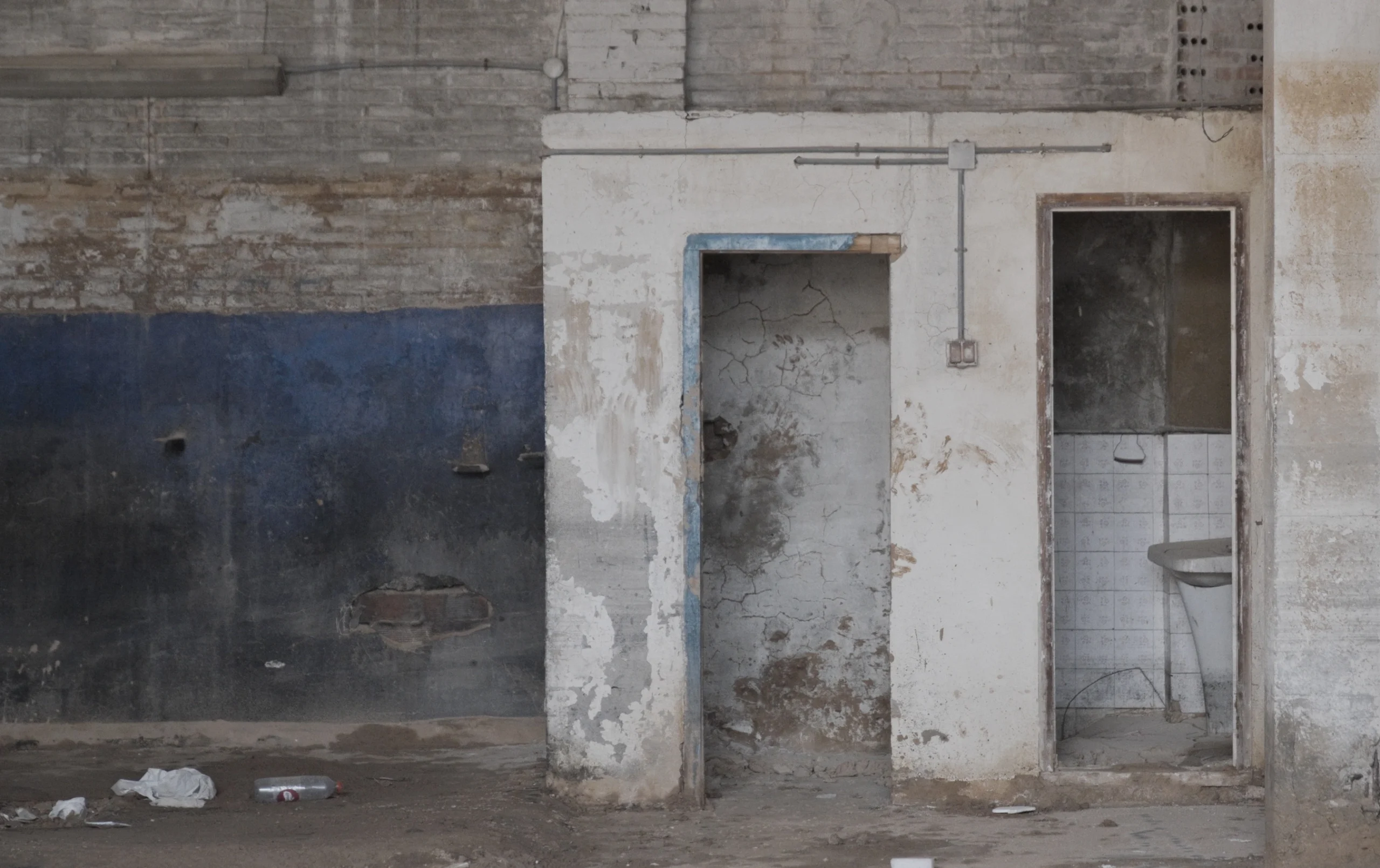 Damaged doors on a white and blue wall after the flood — L’Aigua Recorda